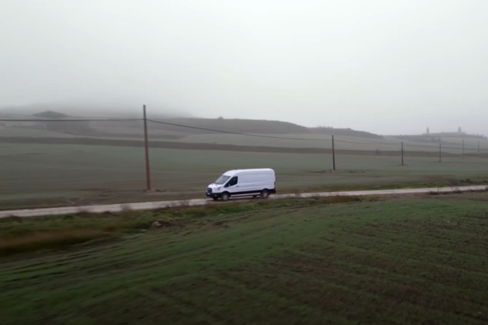 Ford E-Transit recorriendo carretera de campo