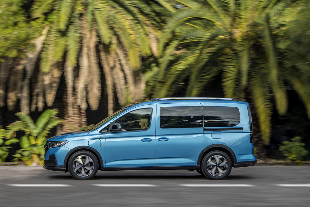 Una furgoneta híbrida enchufable Ford Tourneo Connect azul aparcada en una calle.