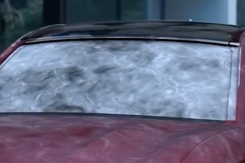 Primer plano de un parabrisas lleno de escarcha de un Ford Mustang Mach-E durante el invierno.