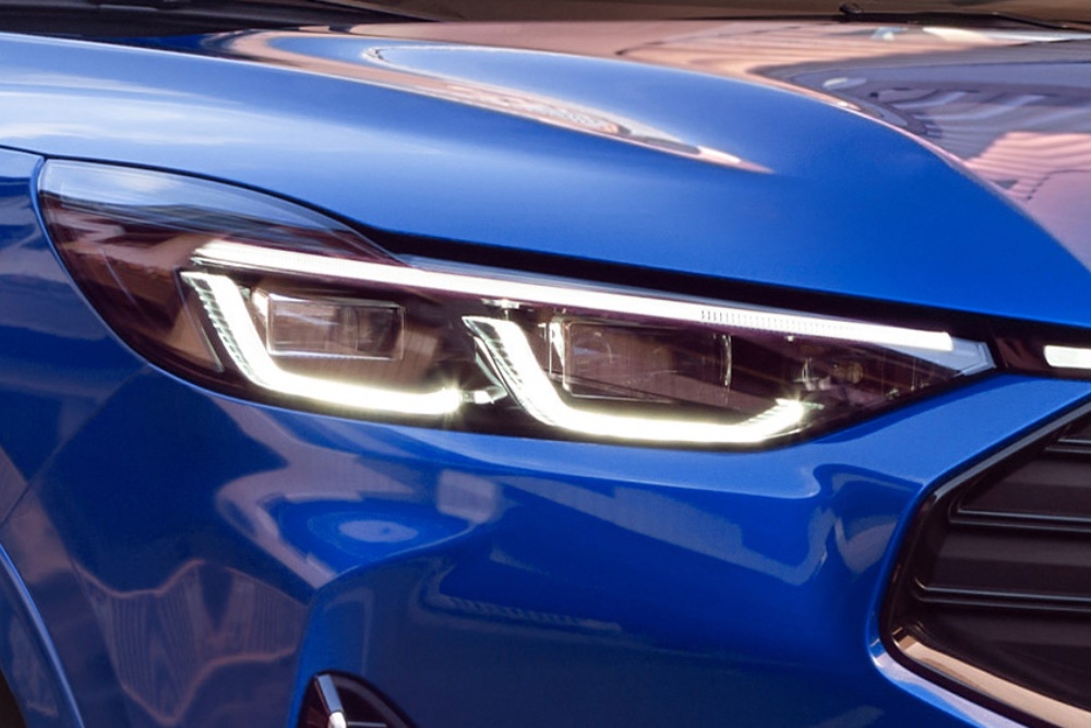 Primer plano del faro delantero de un Ford Mustang Mach-E azul.