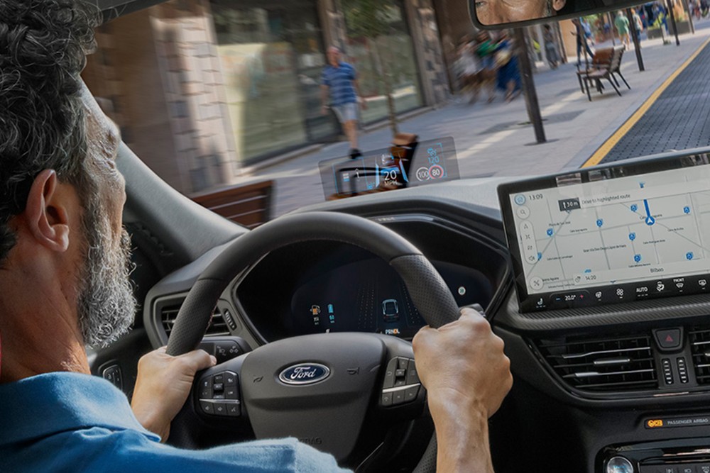 Foto del interior del Ford Kuga con un hombre conduciendo por una vía urbana.
