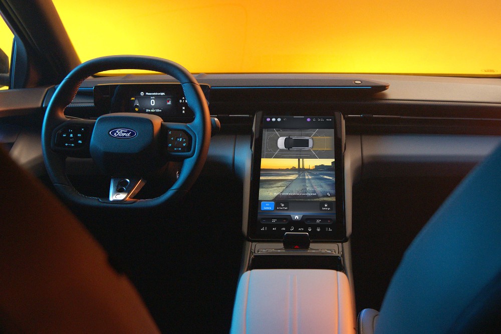 Imagen del interior del Ford Capri totalmente eléctrico que muestra el volante y la pantalla táctil del sistema SYNC Move.