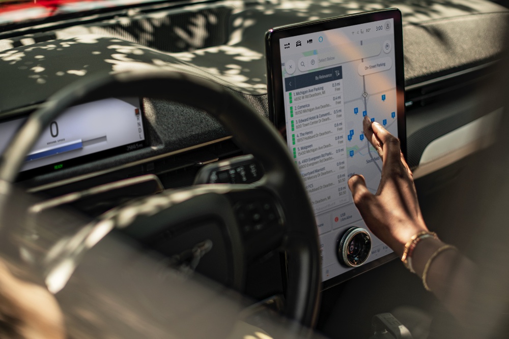Primer plano de una mujer en un Ford Mustang Mach-E manipulando la pantalla táctil SYNC.