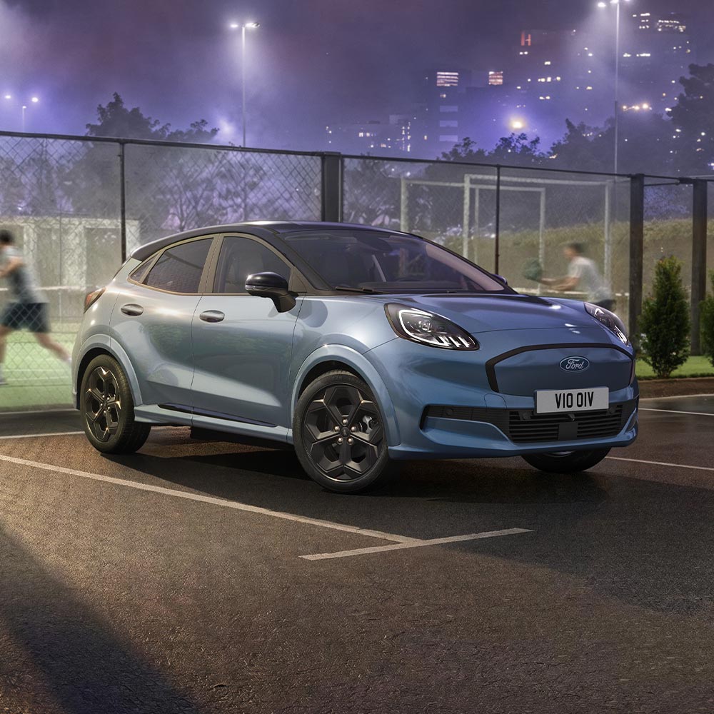 Ford Puma Gen-E Vapour Blue de edición limitada con tecnología BlueCruise aparcado junto a una pista de pádel exterior.