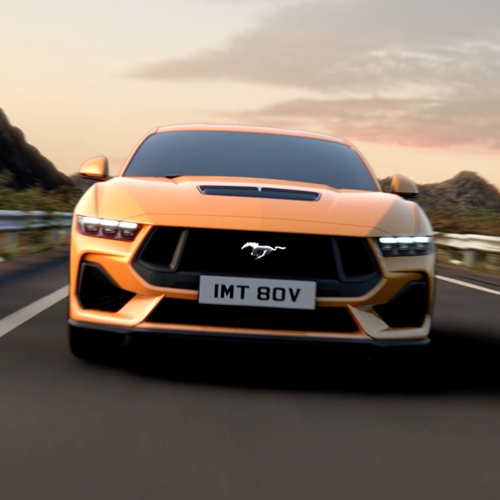 Vista frontal de un Ford Mustang naranja con primer plano de los faros, la parrilla y el emblema Mustang