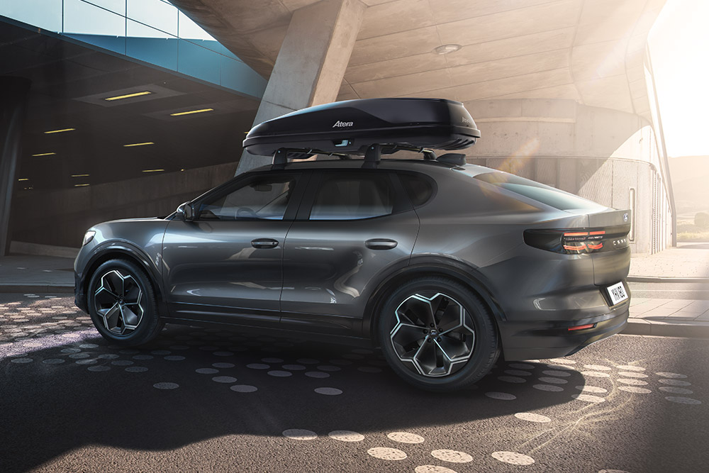 Ford Capri amarillo aparcado en una estructura de hormigón, vista trasera de una caja portaequipajes en la parte trasera con un portaequipajes.