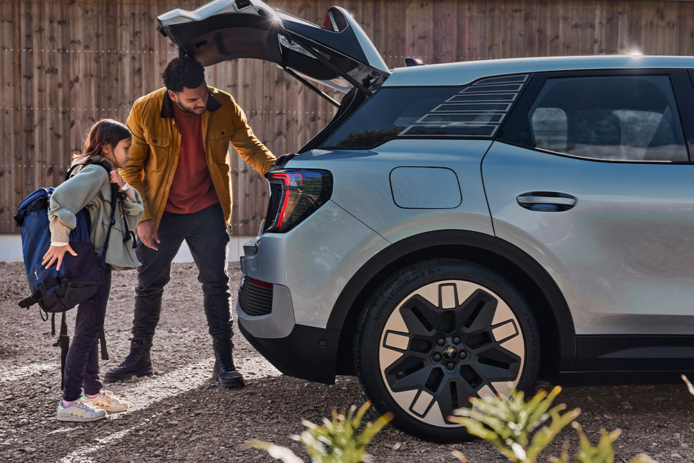 Un padre y una hija cargan el maletero de un Ford Explorer® plateado.