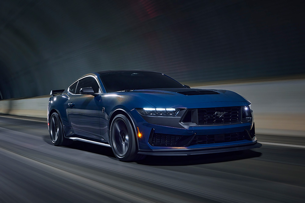 Un deportivo Ford Mustang  de color azul vapor circulando por un túnel.
