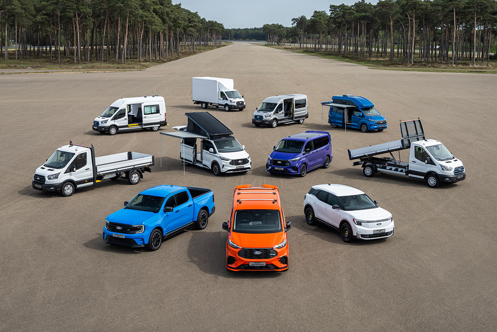 Colección de furgonetas y camionetas Ford Transit estacionadas en un aeródromo.