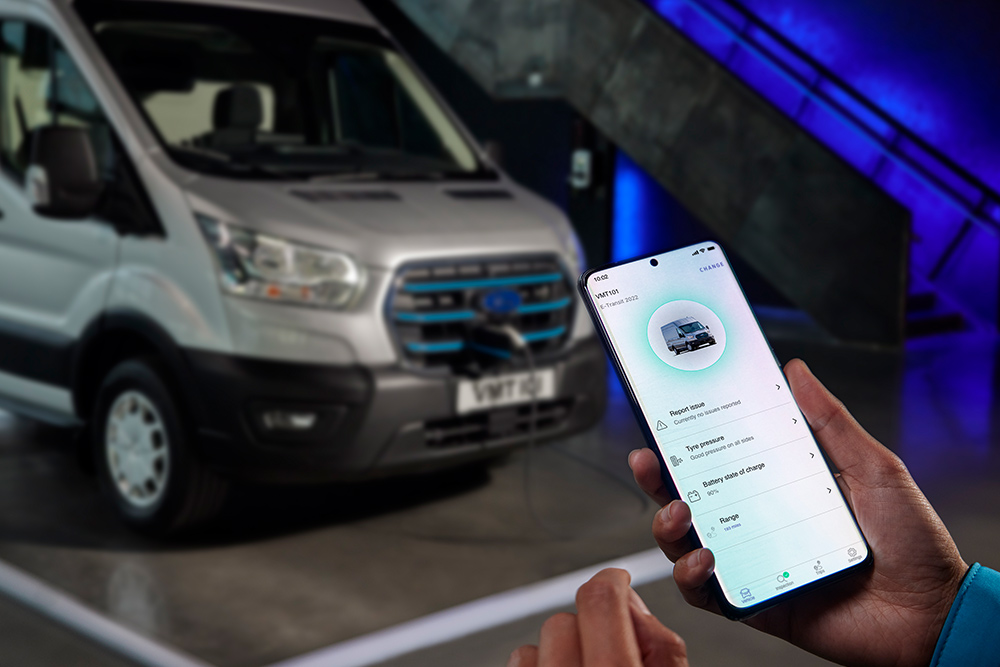 Una mano que sostiene un móvil que muestra la aplicación Ford E-Transit con información del vehículo.