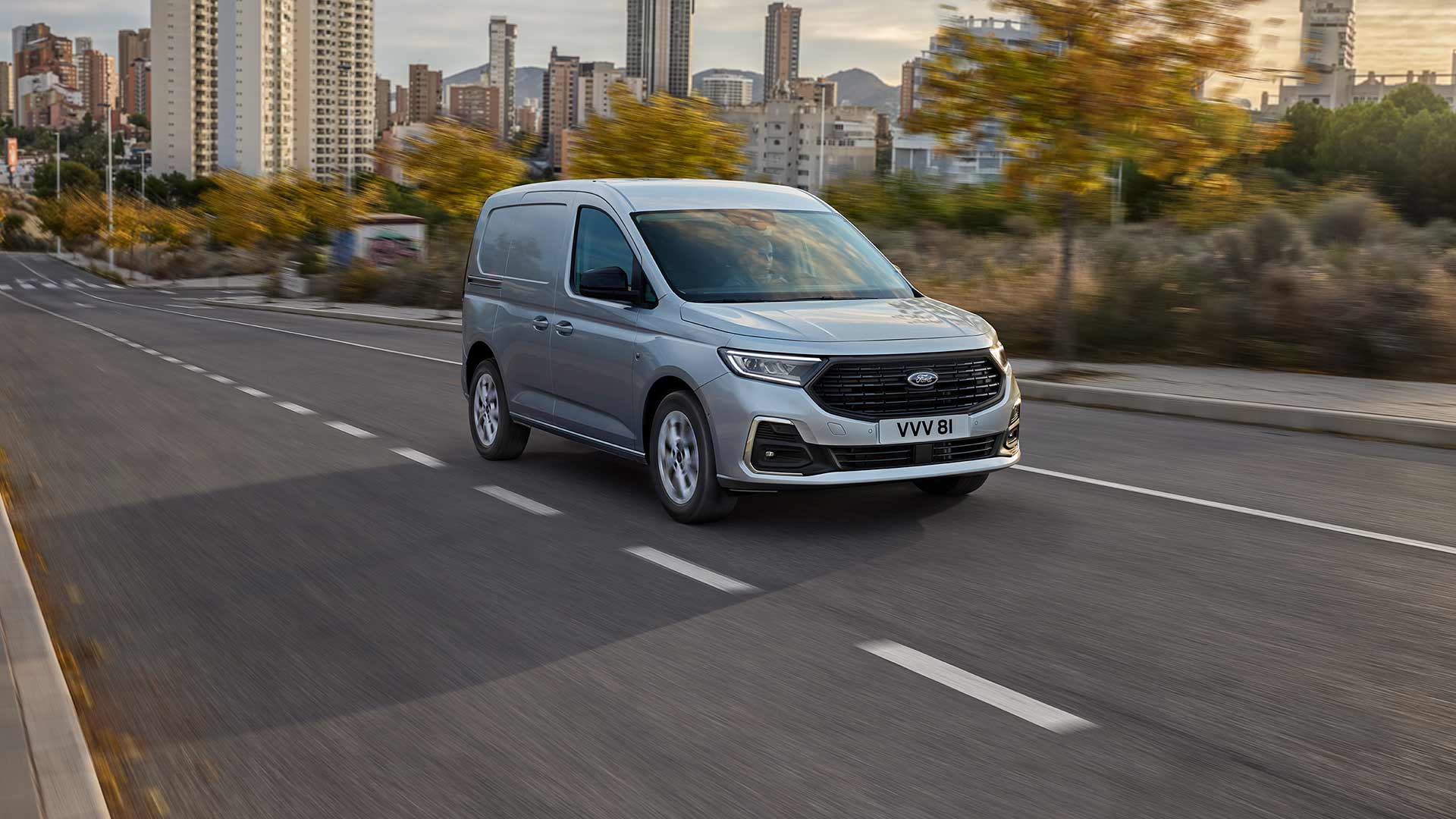 Imagen de una Ford Transit Connect circulando por una ciudad, que muestra los faros antiniebla con embellecedores cromados y los faros automáticos.