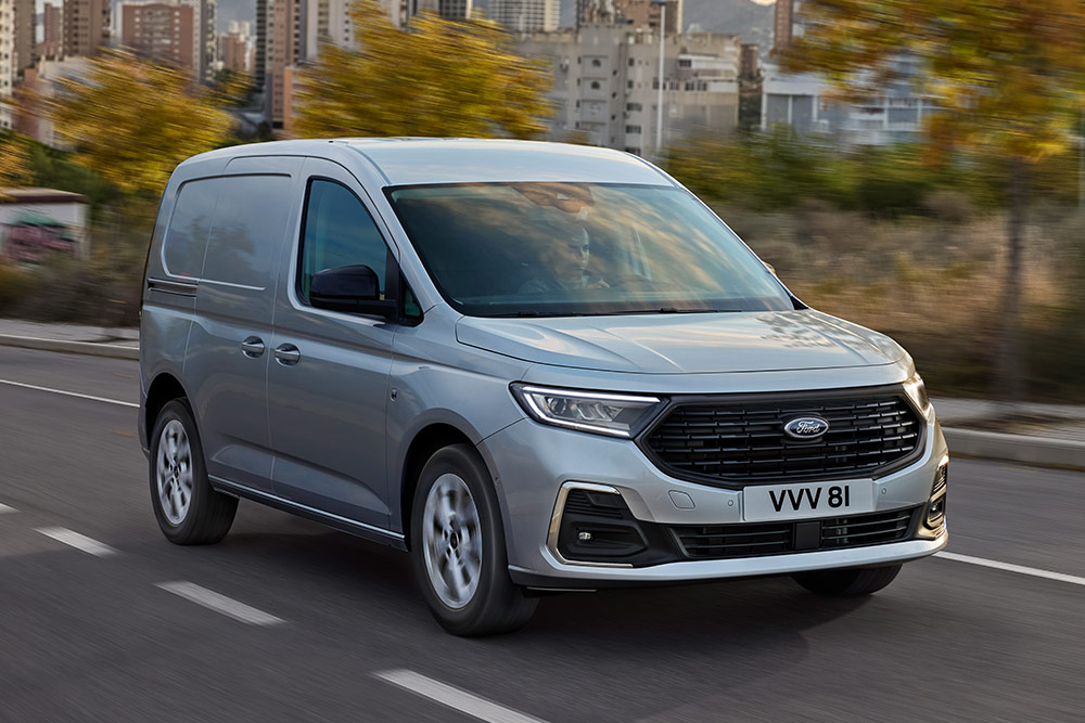 Imagen de una Ford Transit Connect circulando por una ciudad, que muestra los faros antiniebla con embellecedores cromados y los faros automáticos.