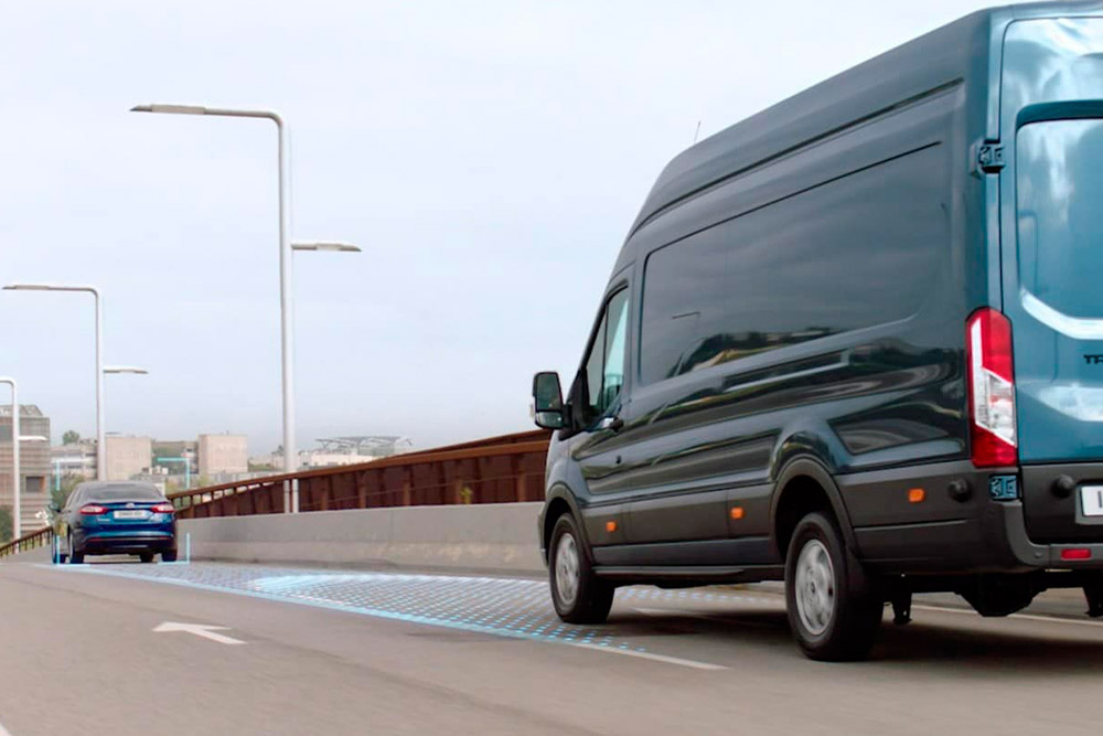 Furgoneta Ford Transit azul con líneas azules en la carretera que representan el uso de los sistemas ADAS avanzados.