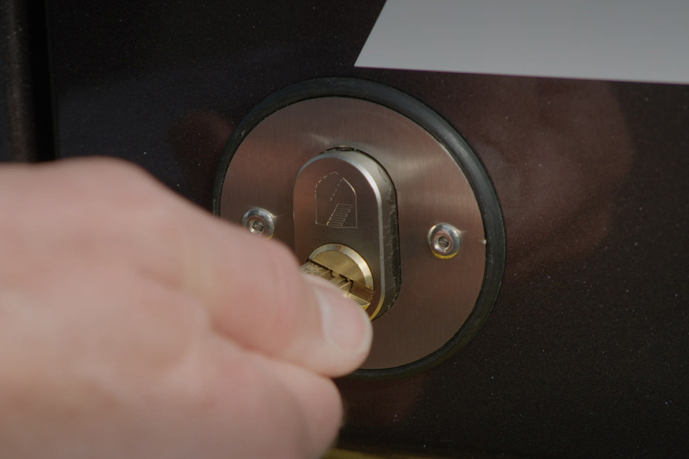 Una mano cerrando la puerta de una furgoneta con una llave.