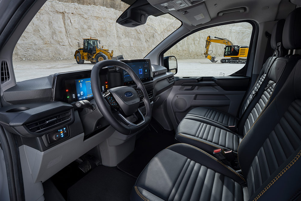 Vista interior de una furgoneta Ford Transit Custom, que muestra el panel de instrumentos, el volante y los asientos.